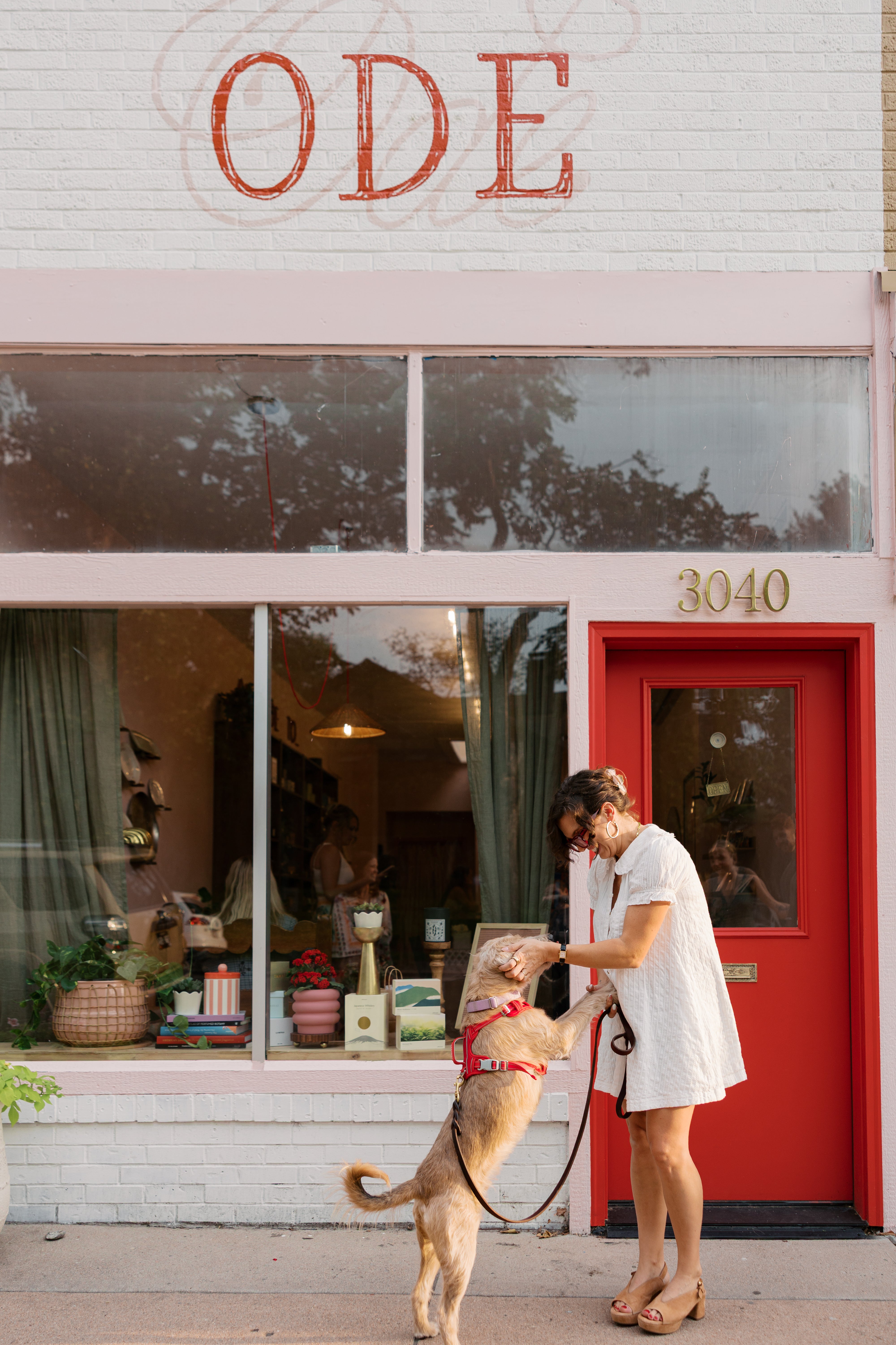 Rachel Greiman with dog, Sunny in front of her store named "Ode To Perfume"